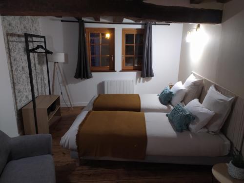 a hotel room with two beds and a couch at Le séchoir Moncontour in Moncontour