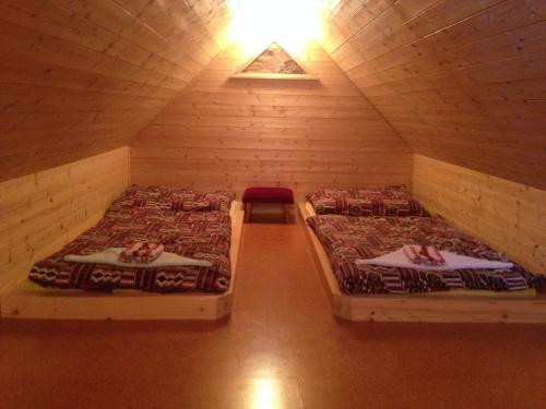 a room with two beds in a wooden cabin at Yveta - Depandance Horské Zátiší in Horni Misecky