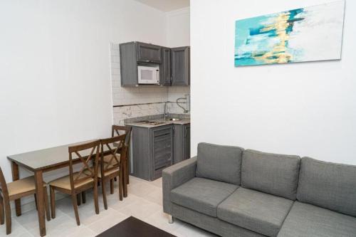 a living room with a couch and a table and a kitchen at Atlantis International Hotel Apartments in Kuwait