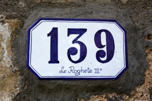 a white and blue sign on a rock at Agriturismo Le Roghete in Acquapendente