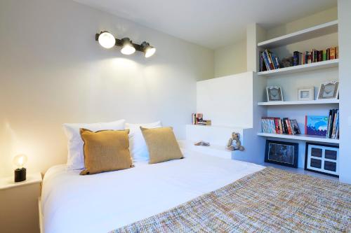 a bedroom with a large white bed with two pillows at Apartments in the countryside near Brussels in Lasne