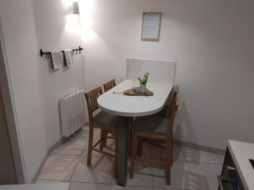 a small white table and chairs in a kitchen at Le séchoir Moncontour in Moncontour