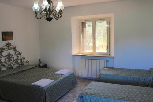 a room with two beds and a window at Agriturismo Vecchio Imposto in Massa Marittima
