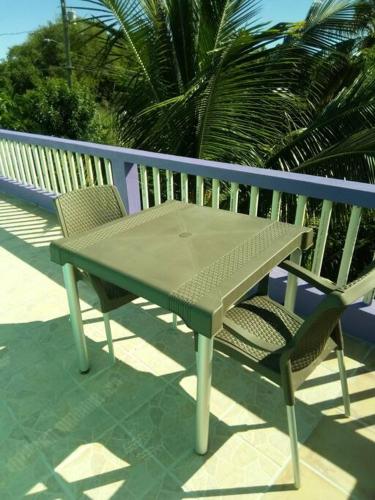 een groene tafel en 2 stoelen op een balkon bij Lynn's Peaceful Space in Willikies