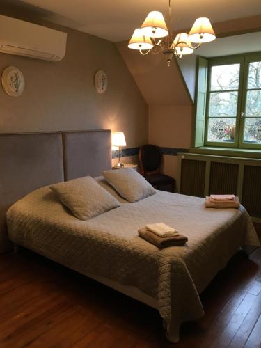 1 dormitorio con 1 cama con 2 toallas en Le Clos Mony, en Chenonceaux