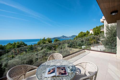 a table and chairs with a view of the ocean at Adria Lux Apartments Sveti Stefan in Budva