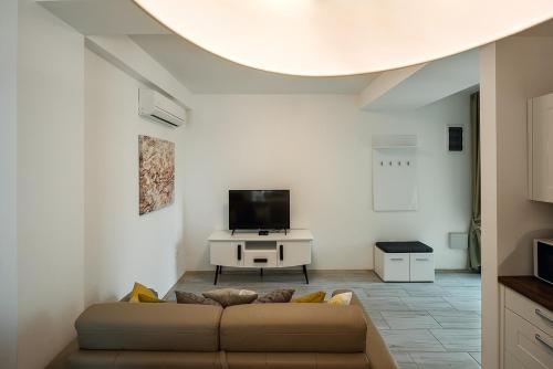 a living room with a couch and a tv at Adria Lux Apartments Sveti Stefan in Budva