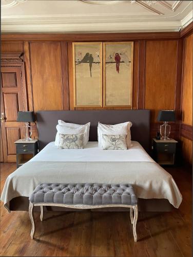a bedroom with a large bed with a bench at Palacio Ramalhete in Lisbon