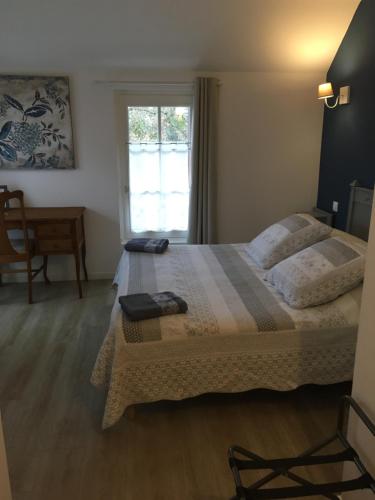 a bedroom with a large bed and a window at Le Clos Mony in Chenonceaux