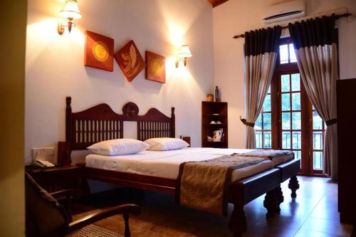 Un dormitorio con una cama grande y una ventana. en Veraima Kandy, en Kandy