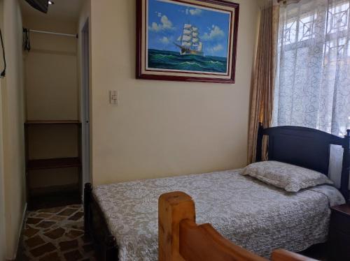 una camera da letto con un letto e un dipinto sul muro di Hotel Andino Real a Bogotá