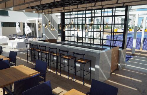 un ristorante con bar con sedie e tavoli di Apart Hotel - Campos dos Goytacazes a Campos dos Goytacazes