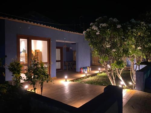 a backyard with a wooden deck at night with lights at Pousada da Mana in Fernando de Noronha