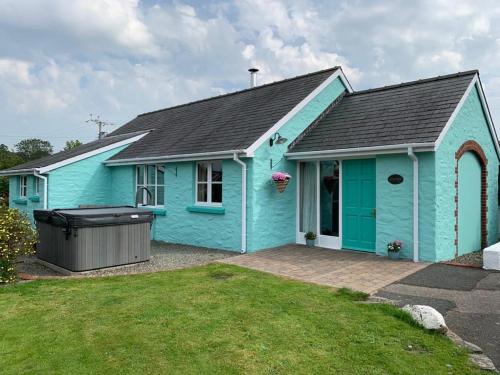 a blue house with a large yard at Canllefaes Cottages in Cardigan