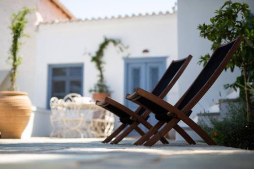 two wooden chairs sitting on a patio with a table at Nefeli Villa in Hydra