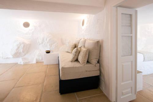 a room with a couch and a white wall at Nefeli Villa in Hydra