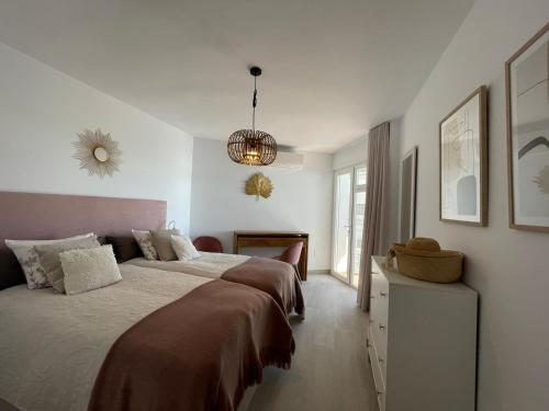 sypialnia z dużym łóżkiem i żyrandolem w obiekcie Nerja city center & sea view Torresol w mieście Nerja