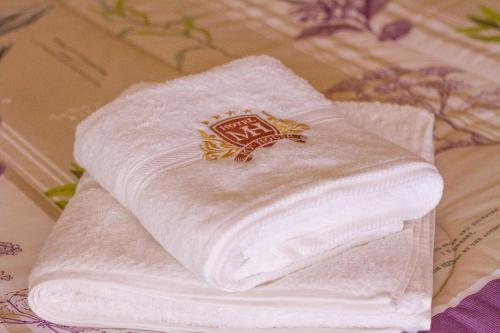 a stack of white towels sitting on a bed at Hotel My House in Salamanca