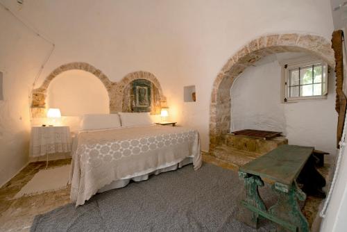 a bedroom with a bed in a room with an archway at Masseria Trulli&Stelle B&B in Noci
