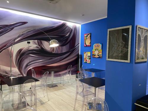 a room with chairs and a painting on the wall at Blue Shades Hotel in Pisa