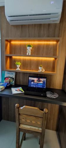 a laptop computer sitting on a desk with a chair at Apartamento Climatizado Familiar NOVO Ed Lírio do Vale Próx ao Termas de Piratuba SC in Piratuba