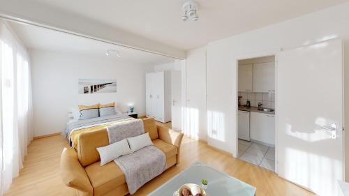 1 dormitorio con 1 cama y 1 sofá en Unique Serviced Living @ St. Johann Davidsrain en Basilea