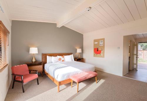 a bedroom with a bed and two chairs at Contenta Inn in Carmel Valley