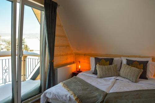 a bedroom with a bed and a balcony at Okno na gorce in Frydman