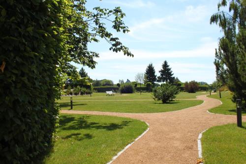 a path in a park with grass and trees at SEETELHOTEL Nautic Usedom Hotel & Spa das Hotel für Wellness & Genuss auf Usedom in Ostseebad Koserow