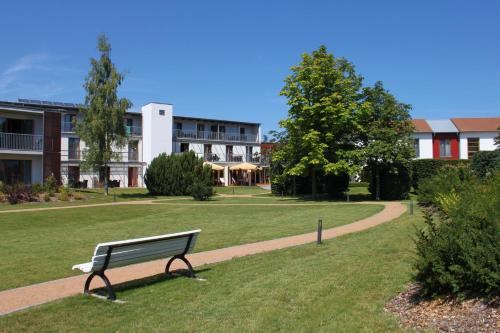 a park bench in front of a building at SEETELHOTEL Nautic Usedom Hotel & Spa das Hotel für Wellness & Genuss auf Usedom in Ostseebad Koserow