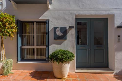 a house with a blue door and a potted plant at Apartamento Seis Lunas PA in Marbella
