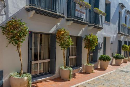 a row of potted trees inront of a building at Apartamento Seis Lunas PA in Marbella