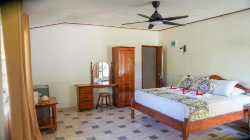 Schlafzimmer mit einem Bett und einem Deckenventilator in der Unterkunft Villa Antonia in La Digue