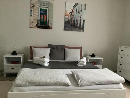 sypialnia z łóżkiem z dwoma obrazami na ścianie w obiekcie Ezüst Boróka Apartman w Egerze