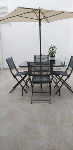 a table and chairs with an umbrella in a room at Na Chicca e na Nicchia in San Pancrazio Salentino