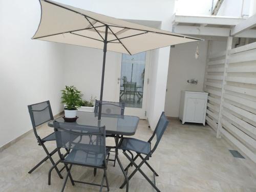 a table and chairs with an umbrella on a patio at Na Chicca e na Nicchia in San Pancrazio Salentino