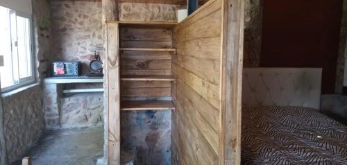 a bunk bed in a room with a wooden wall at Cabañas La Rústica in Bialet Massé
