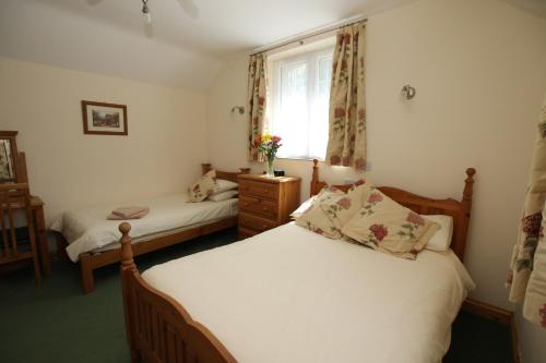 a bedroom with two beds and a window at Chy un Lur Rural cottage in Truro
