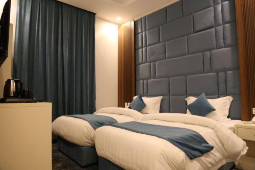 a bedroom with a large bed with a large headboard at شقق ارين المطار in Jeddah