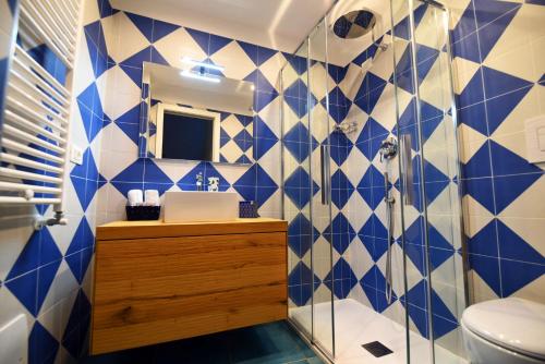 La salle de bains est pourvue de carrelage bleu et blanc. dans l'établissement Appartamento - Antica Residenza Amalfitana, à Amalfi