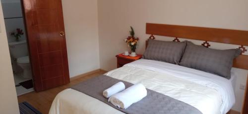 a bedroom with a bed with two towels on it at Qente Wings in Ollantaytambo