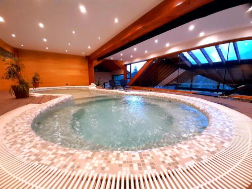 a large swimming pool in a building with a building at La Estancia Cabañas in Villa La Angostura