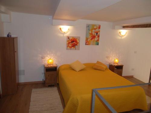 um quarto com uma cama amarela e duas luzes na parede em Vesna Loft in Luino em Luino