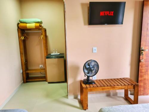 a mirror in a room with a table and a fan at Pássaros do Cerrado Suítes in Alto Paraíso de Goiás
