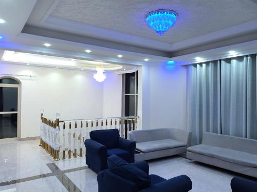 a living room with a couch and chairs and a chandelier at Enayath Homes 5 BedRoom Villa with swimming pool in Ajman 