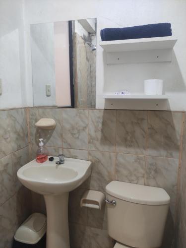 a bathroom with a sink and a toilet and a mirror at Casa Sucre Ayacucho in Ayacucho