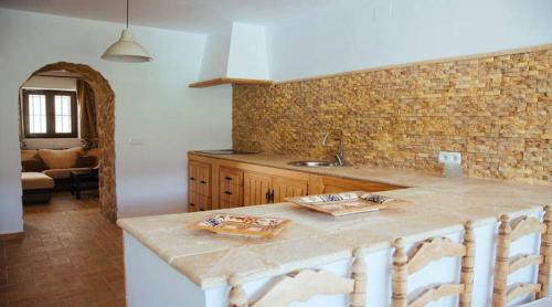 eine Küche mit einer Arbeitsplatte und ein Wohnzimmer in der Unterkunft Spanish Townhouse in Spa Village/ Casa rural in Carratraca
