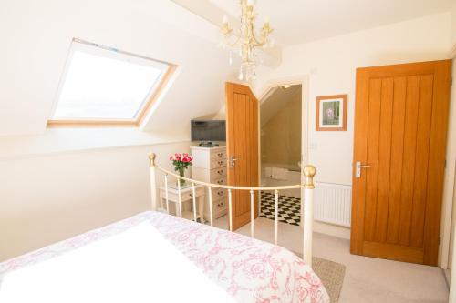 a bedroom with a bed and a window at Higher Weddicott Barn Holiday Cottage - Self Catering in Chagford