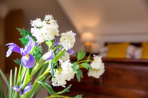 a vase filled with purple and white flowers at Higher Weddicott Barn Holiday Cottage - Self Catering in Chagford