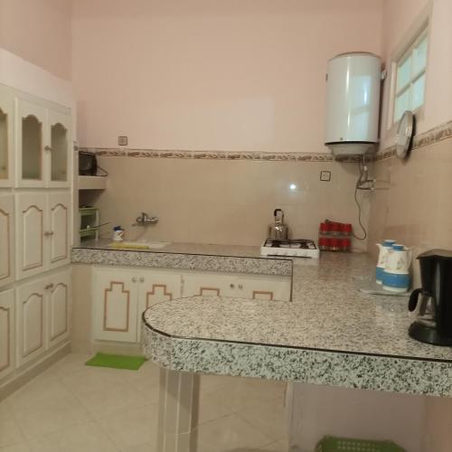 a kitchen with a counter top in a room at Maison de vacances zuine in Oujda